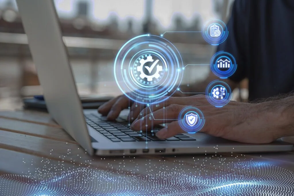 Hands typing on a laptop with data quality icons.