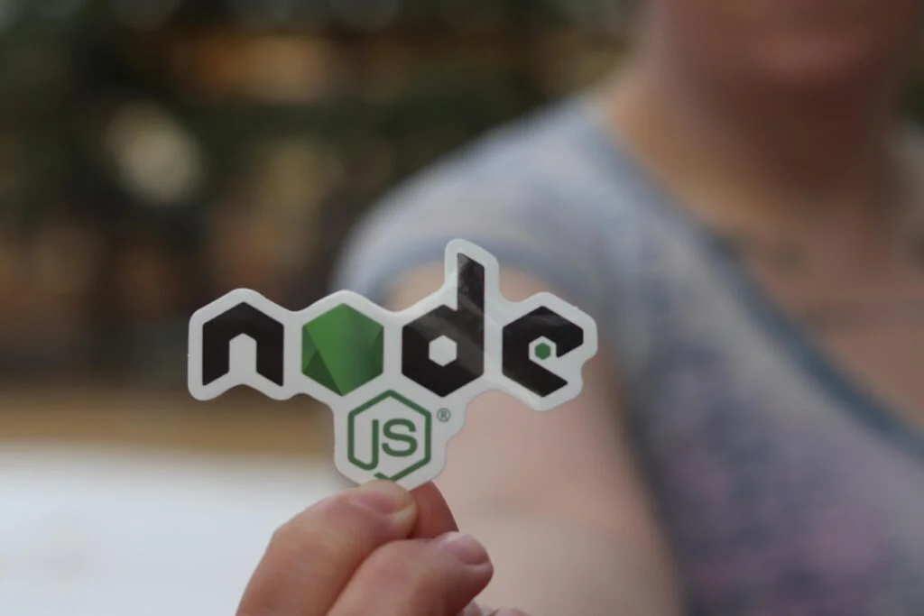 Hand holding a Node.js logo sticker.