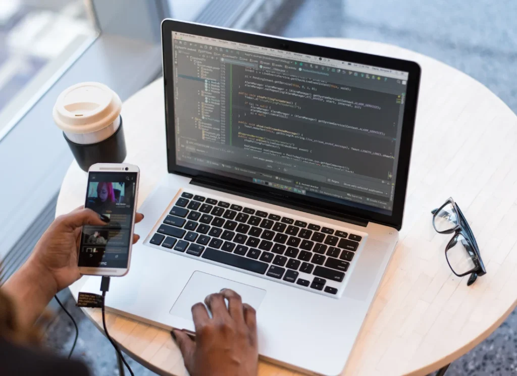 Top view of hands typing on a laptop for iOS app development